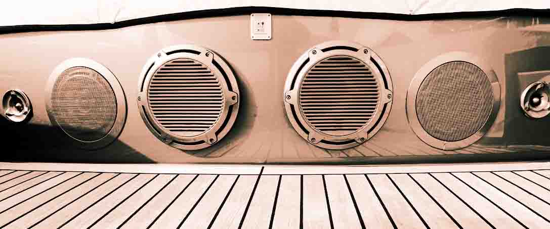 Several music speakers are integrated into the luxury yacht hull. Music speaker integrated into the sofa body on the teak deck of a luxury yacht