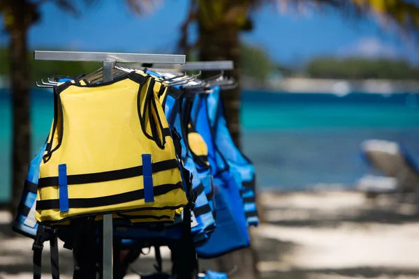 Multiple life jackets arranged on a beach, pointing to the boat safety and survival category